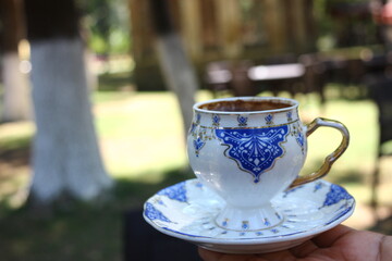 Hand holding cup of turkish coffee in nature