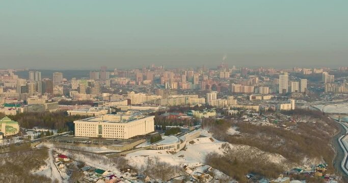Government house Republic of Bashkortostan. The building of the city administration of Ufa on the mountain and the background of the city at winter sunset. Aerial drone view