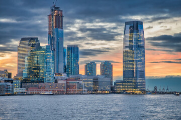 Sunset skyline of Jersey City as seen from a ferry boat tour around New York City.