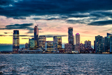 Fototapeta premium Sunset skyline of Jersey City as seen from a ferry boat tour around New York City.