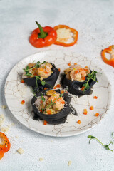 Black pancakes stuffed with red salmon caviar