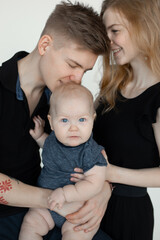 Vertical photo smiling calm family, woman, man and baby, kissing and spending time together. Father daughter. Close up