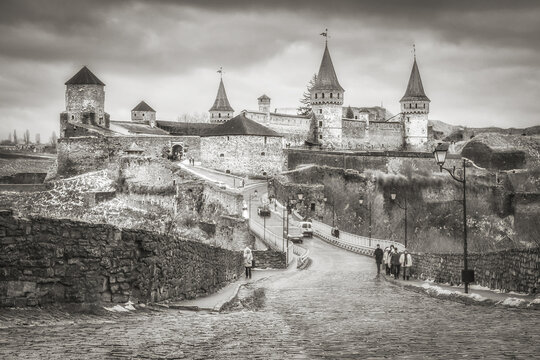 Dramatic lighting as storm clouds gather around Medieval gothic castle on the hill.   Old castle photo on a postcard or cover. Long exposive