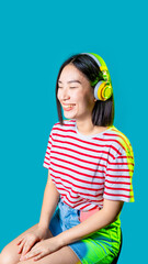Young asiatic woman wearing wireless headphones listening music