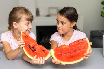 Two kids eating one slice of watermelon. Kids eat fruit outdoors. Healthy snack for children.