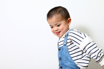 オーバーオールを着ている坊主頭の男の子。