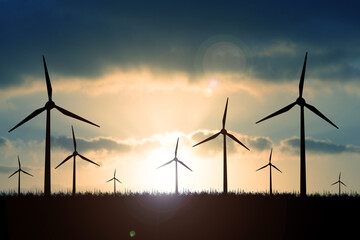 Wind turbines generate energy power electricity during the evening. The sun goes down. Silhouettes, wind turbines, clean energy in the evening
