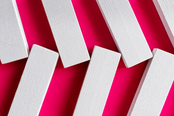 close up of white quadrangular blocks on pink background, top view.