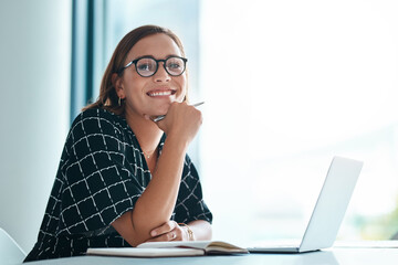 Its a lightbulb moment. Cropped portrait of a happy young businesswoman working on a laptop in an...