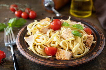 Mediterranean cuisine, seafood diet. Italian spaghetti pasta savory salmon with bechamel sauce on a rustic tabletop.