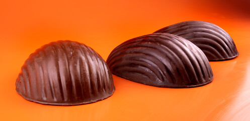 three easter chocolate eggs on orange background