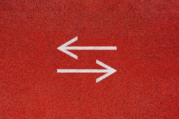 Two white arrows opposite each other on a red background