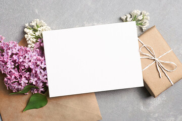 Greeting or invitation card mockup with gift box, envelope and spring lilac flowers
