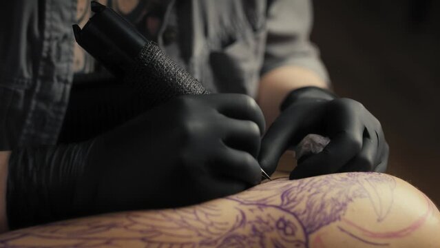 Close up of tattoo artist drawing on arm of client. Shot with RED helium camera in 8K.  