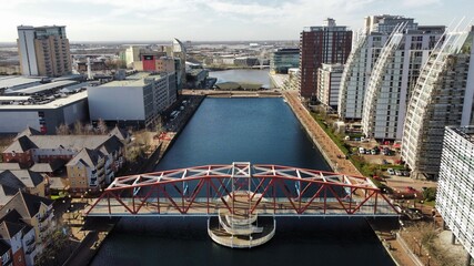 Drone image of Salford Quays with modern buildings and landmarks and views towards Manchester. 