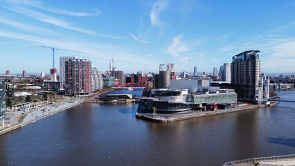 Fototapeta premium Drone image of Salford Quays with modern buildings and landmarks and views towards Manchester. 