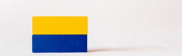 blue and yellow quadrangular blocks on white background with copy space, ukrainian concept, banner.