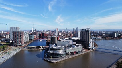 Naklejka premium Drone image of Salford Quays with modern buildings and landmarks and views towards Manchester. 