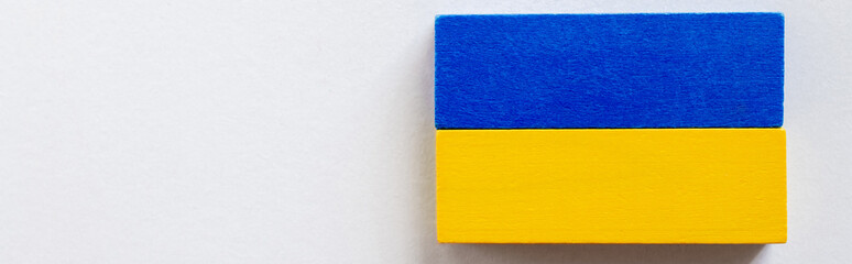 top view of tetragonal blue and yellow blocks on white background, ukrainian concept, banner.