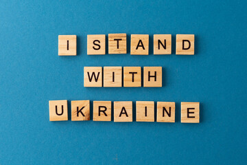 I stand with Ukraine background. Phrase from wooden letters. Support Ukrainian people. Stop war. Top view words. The phrases is laid out in wood letter. Motivation.