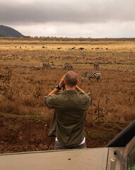 Hombre observando las cebras durante un safari en Tanzania © Belatribe