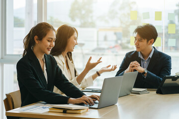 Three young Asian businesswomen and businessman at the meeting in a conference room.