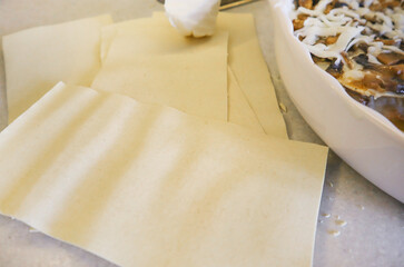 Cooking traditional homemade lasagna. Lasagna sheets NEAR A ROUND CERAMIC BAKING DISH Top View