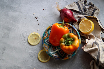 Top view photo of fresh seasonal vegetables on a table. Vibrant colors of bell pepper and two artichokes. Healthy eating concept. 
