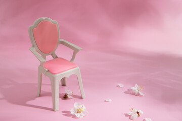 Abstract composition spring still life puppet chair with white flower on pink background