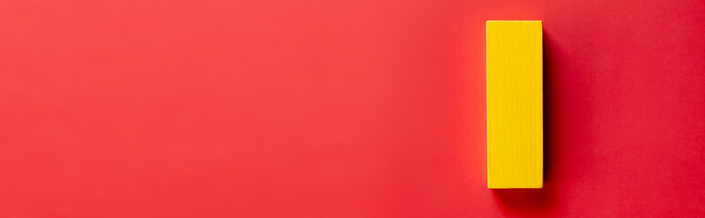 top view of yellow block on red background with copy space, banner.