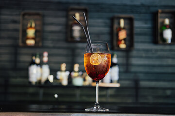 Red cocktail with ice and lime in glass in the bar.