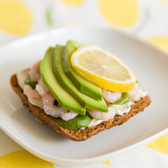 Closeup of homemade sandwich with fresh shrimps, avocado, cream cheese and lemon. Healthy food for family.