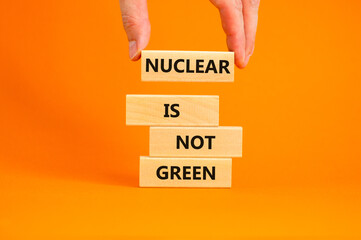 Nuclear is not green symbol. Concept words Nuclear is not green on wooden blocks. Businessman hand. Beautiful orange table orange background. Nuclear is not green business concept. Copy space.