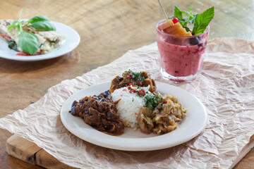 Beef and chicken curry served with rice, traditional salads and a smoothie 