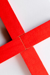 close up of cross made of red blocks on white background, top view.