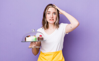 pretty caucasian woman feeling stressed, anxious or scared, with hands on head. home made cakes...
