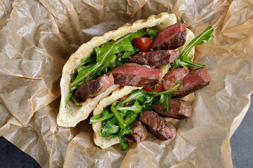 Gyros, shawarma with meat and herbs, on paper
