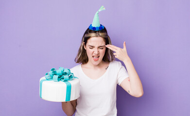 pretty caucasian woman looking unhappy and stressed, suicide gesture making gun sign. birthday...