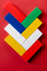 top view of bright multicolored rectangular blocks on red background.