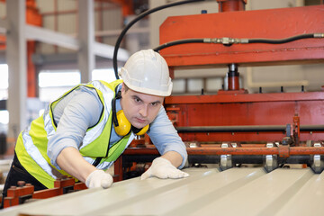 Caucasian Worker Checking on the Metal Sheet From the Machine