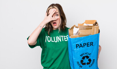 pretty caucasian woman looking shocked, scared or terrified, covering face with hand. ecology...