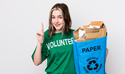 pretty caucasian woman smiling and looking friendly, showing number one. ecology concept