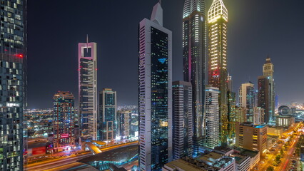 Fototapeta premium Aerial view of Dubai International Financial District with many skyscrapers night timelapse.