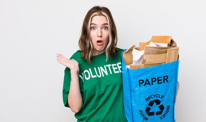 pretty caucasian woman looking surprised and shocked, with jaw dropped holding an object. ecology...