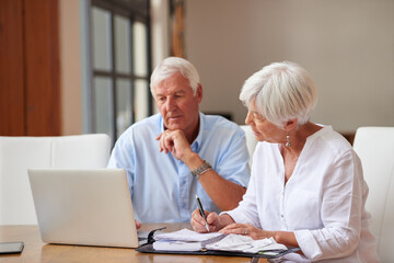 That cant be right. Shot of a senior couple going over some paperwork while using a laptop. - obrazy, fototapety, plakaty