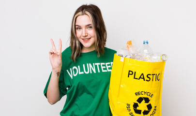 pretty caucasian woman smiling and looking friendly, showing number two. ecology concept