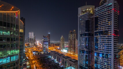 Aerial view of Dubai International Financial District with many skyscrapers night timelapse.