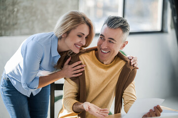 A couple in the office looking interetsed while reading news