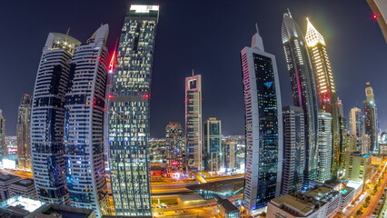 Aerial view of Dubai International Financial District with many skyscrapers all night timelapse.