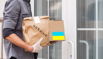 a man holds a box with humanitarian aid to ukraine